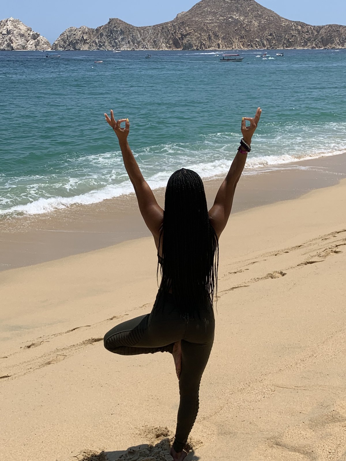 Dana Macc in tree pose on the beach in Cabo