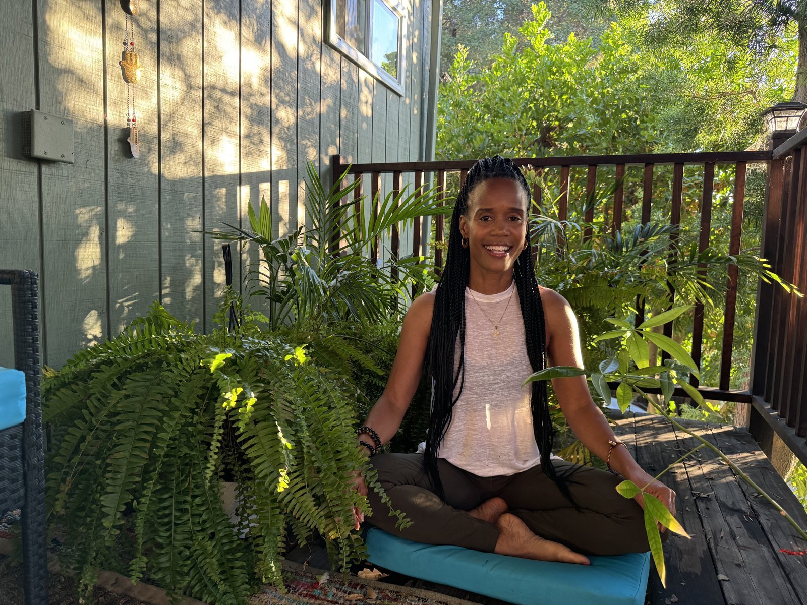 Dana Macc seated in meditation among plants